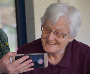 Seniorin schaut auf Smartphone